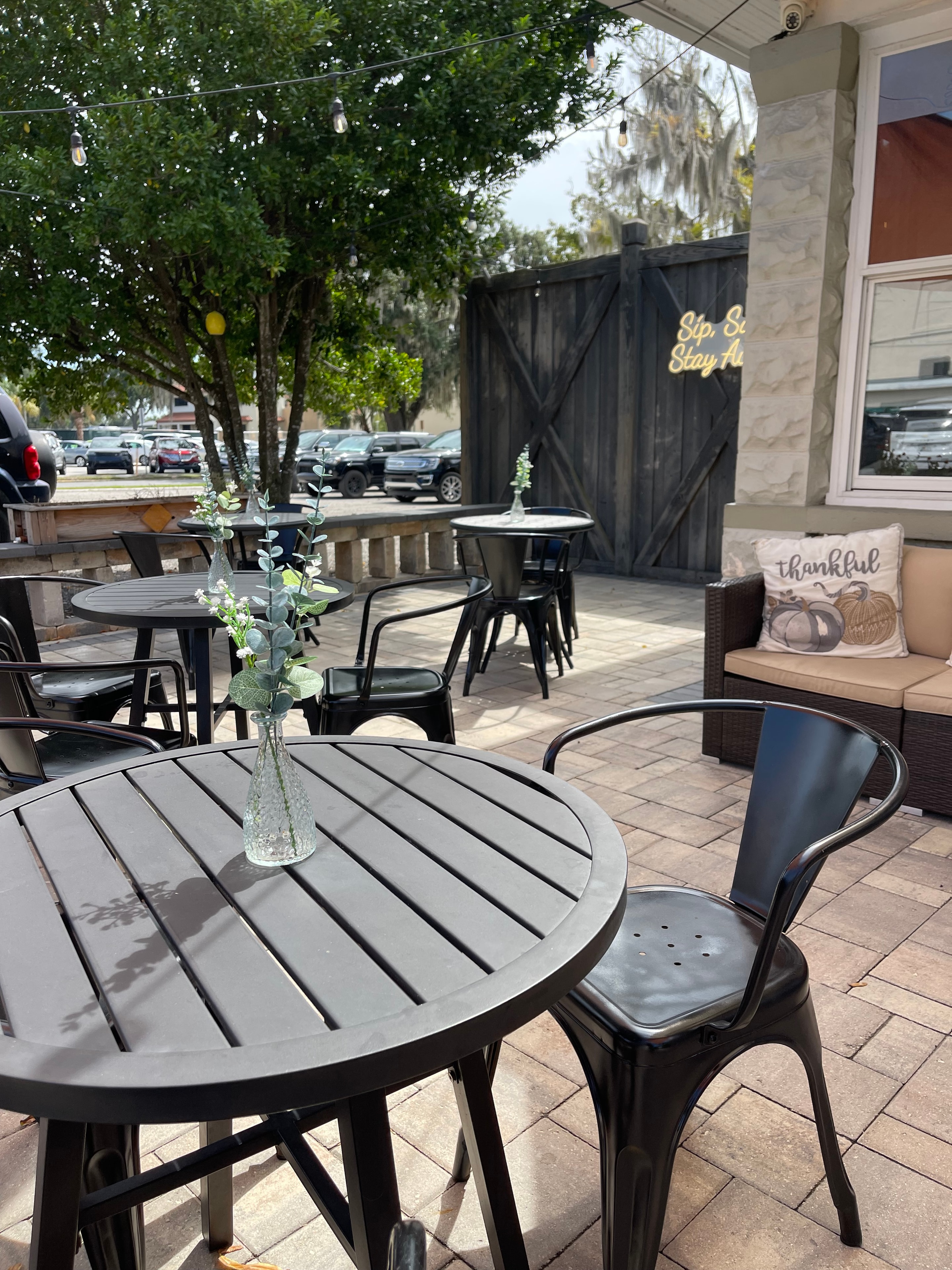Outdoor patio with Sip Stay sign at The Social Cellar