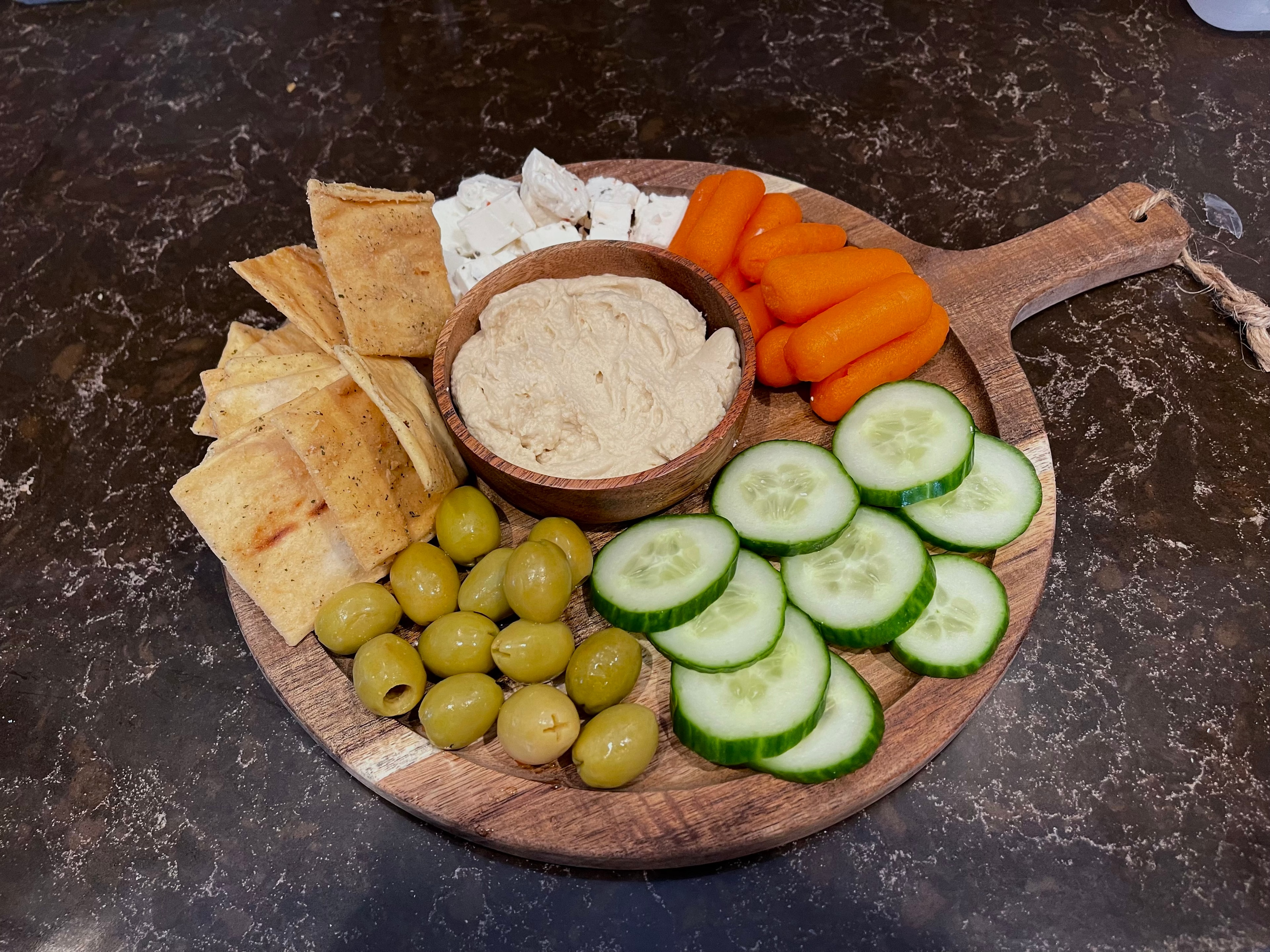 Hummus board with pita, olives, carrots and cucumber at The Social Cellar